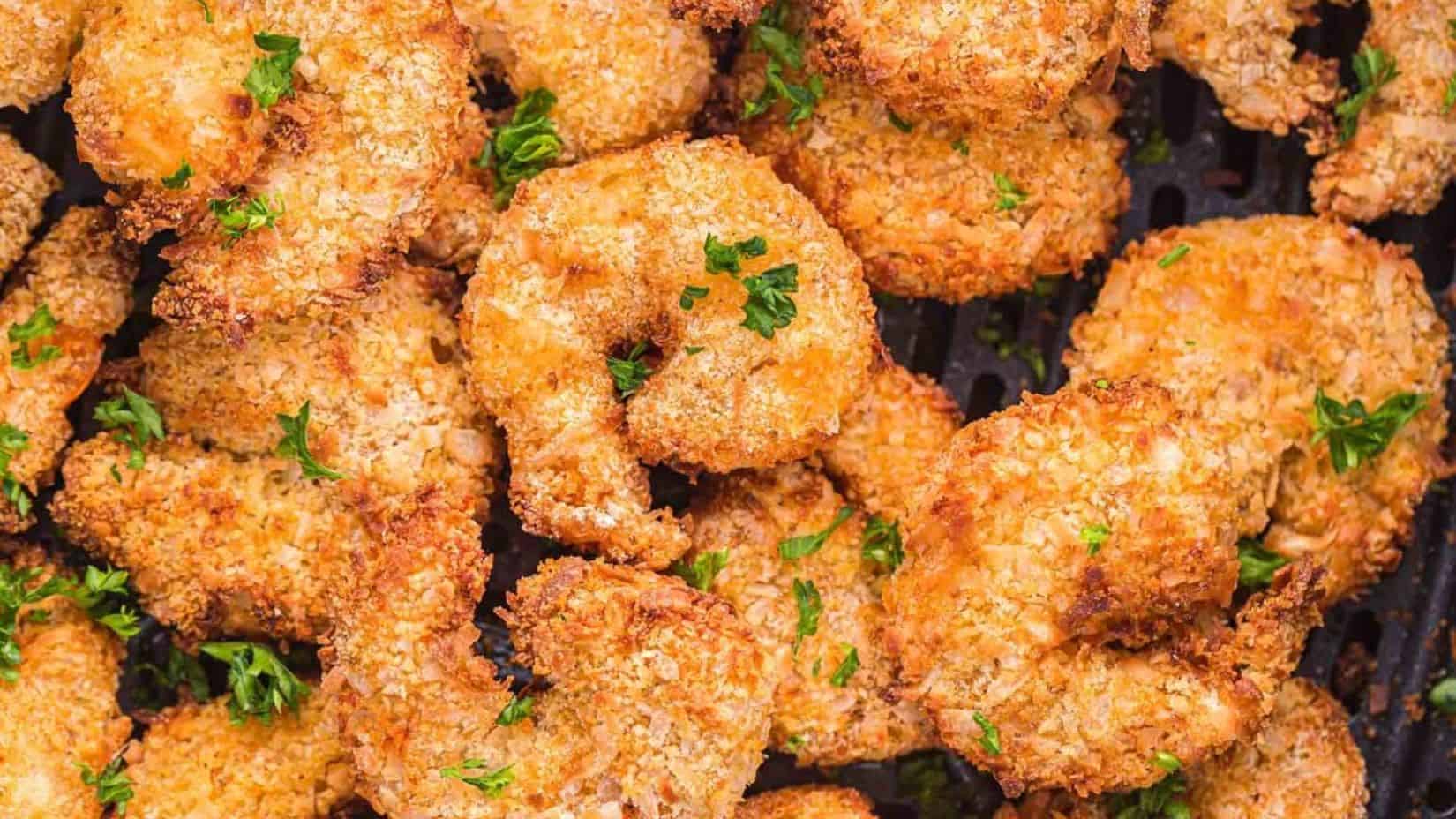 A close-up shot of coconut shrimp on the air fryer tray.