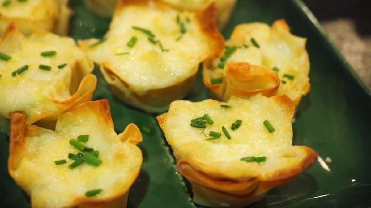 A close-up shot of a couple numbers of artichoke cheese wontons, set on a plate.