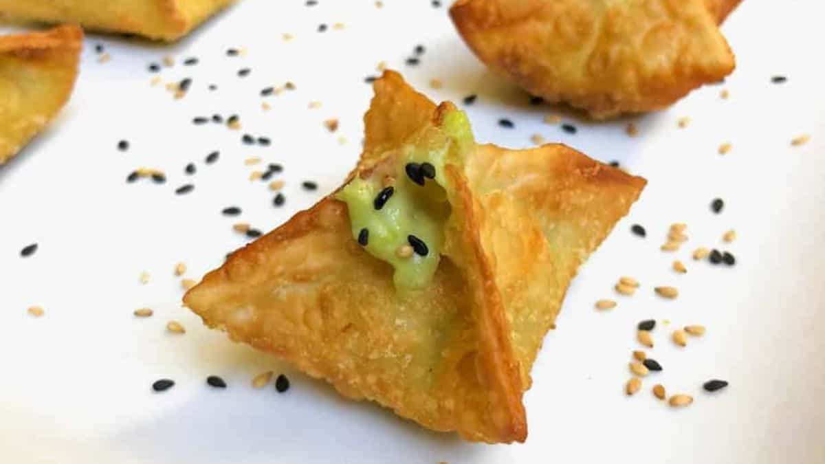A couple of pieces Avocado Cream Cheese Filled Wonton set on a plate. 