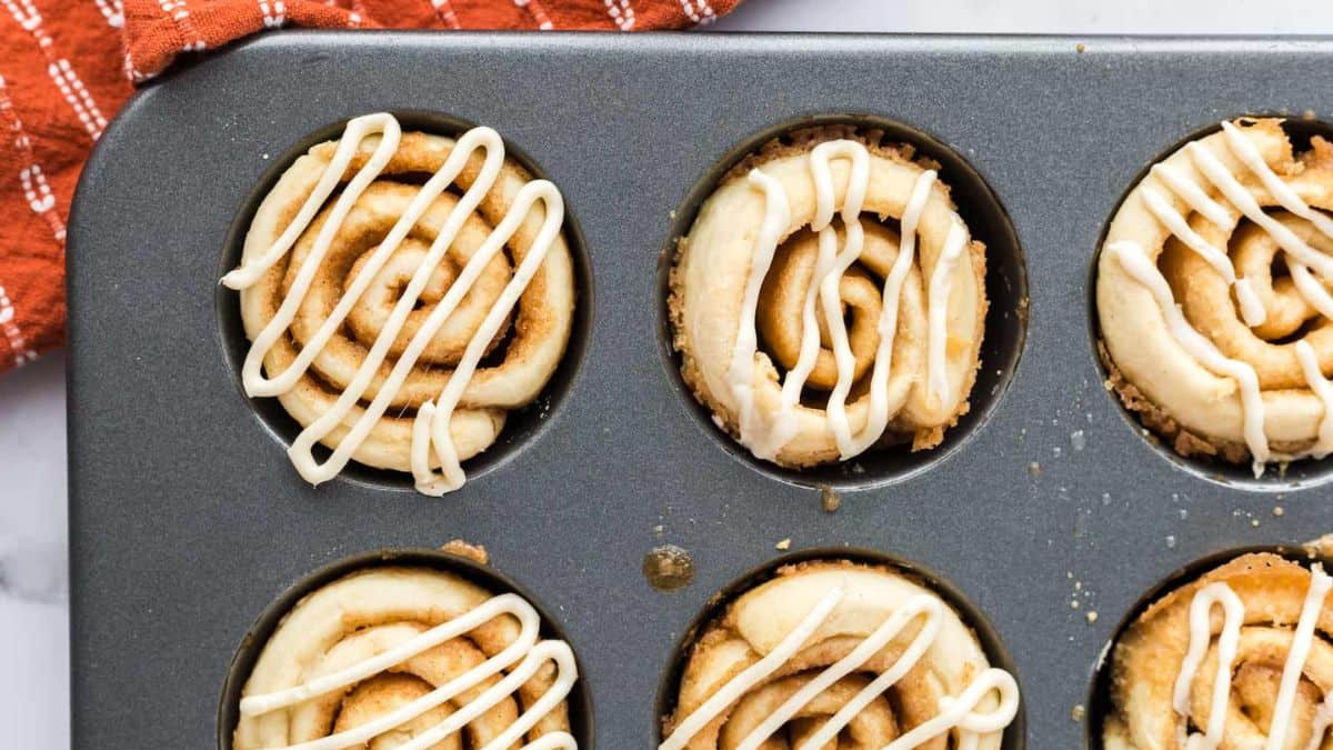 A top shot of a muffin tray filled with cinnamon muffins.