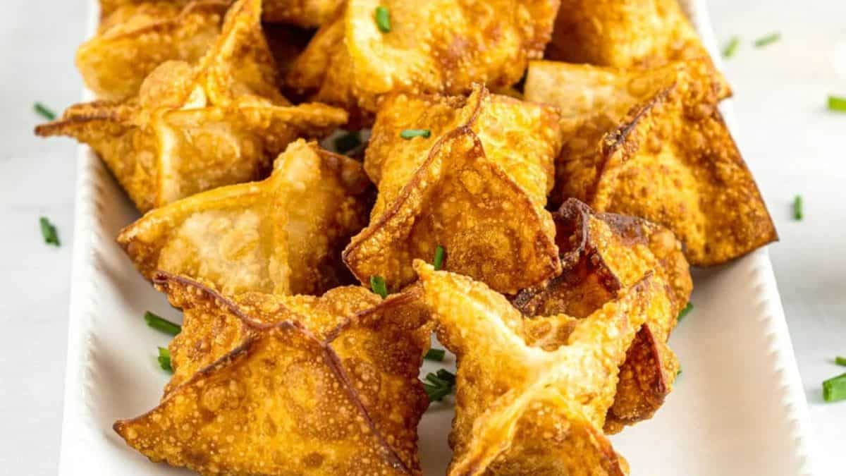 A close-up shot of couple of Crab Rangoon piled together in a plate. 
