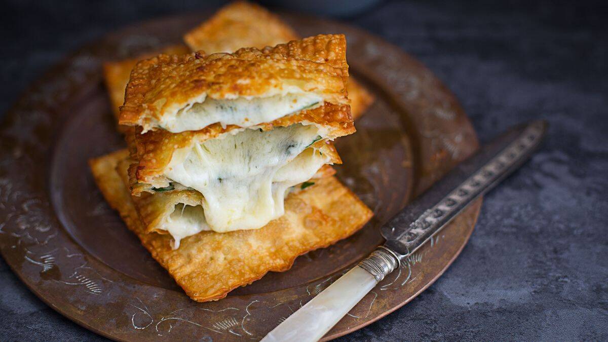 A pile of Crunchy Spinach and Cheese Gozleme set on a plate. 