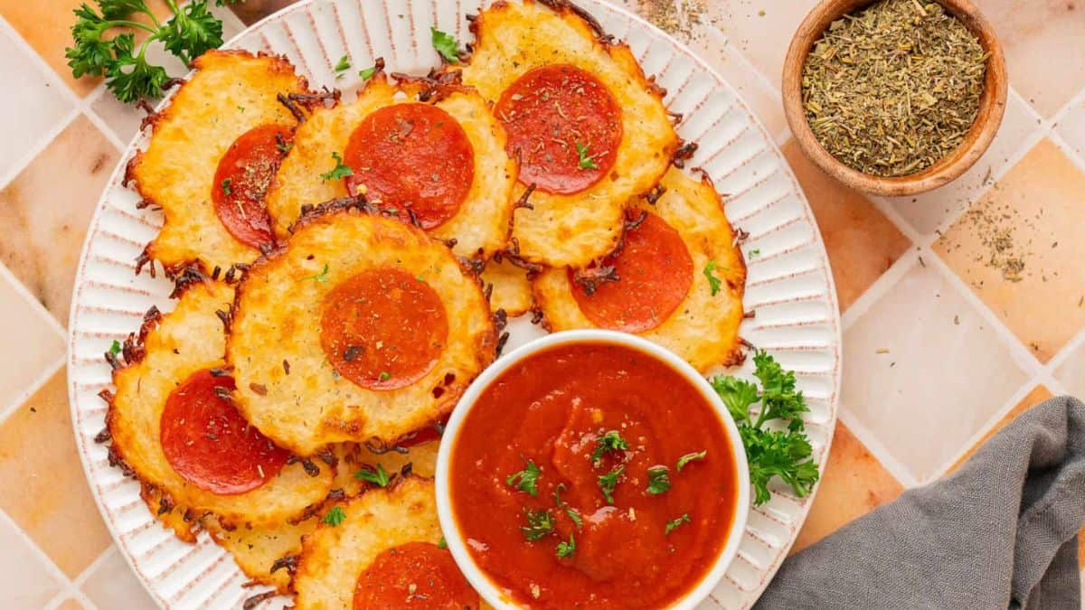 Keto Pizza Chips set on white plate, with marinara sauce dip on the side. 