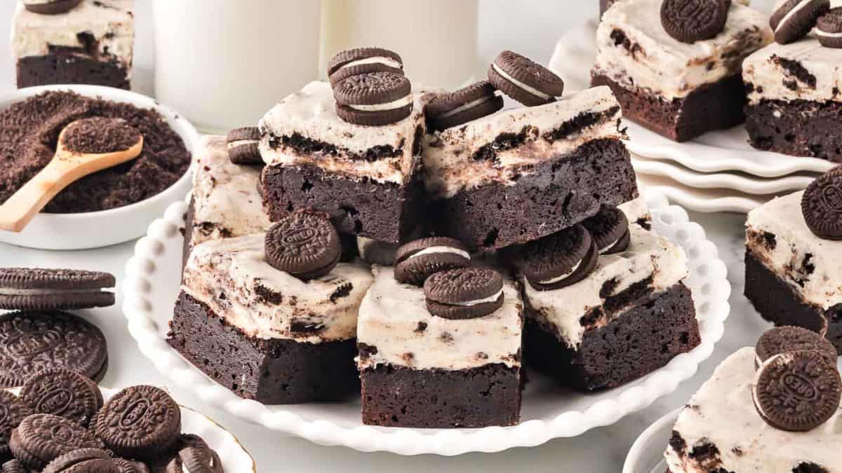 A couple of Oreo Cheesecake Brownies piled up on a plate. 