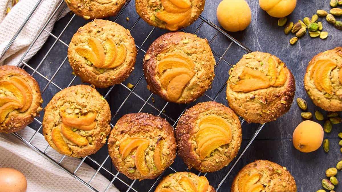 Top shot of a couple of Pistachio Muffins laid across a surface.