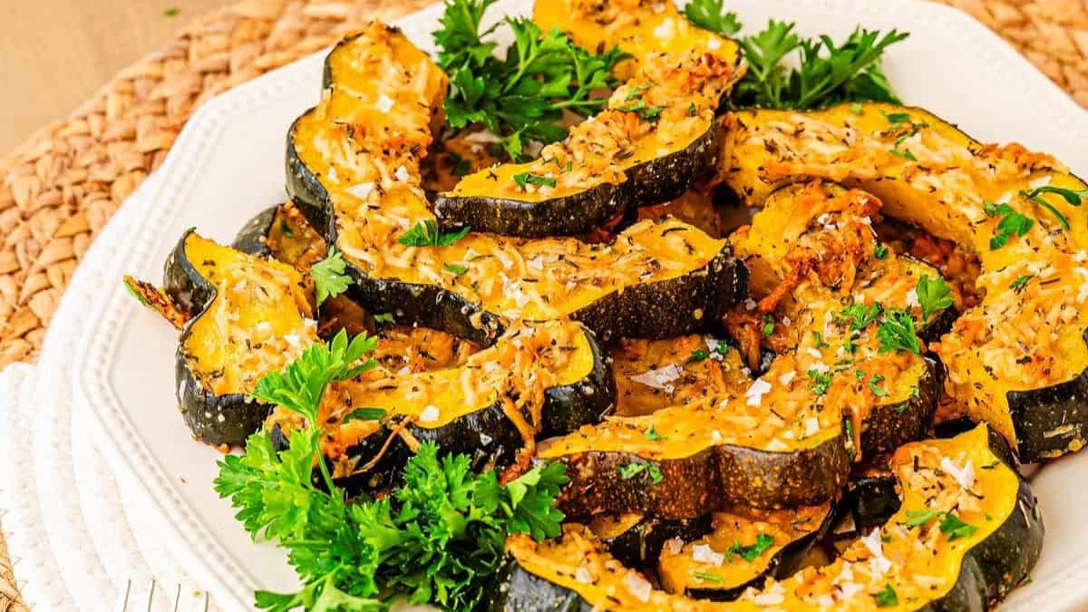 A serving white plate filled with roasted acorn slices, 