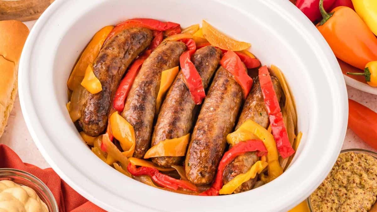 Bratwurst with Onions and Pepper served in a slow cooker pot. 