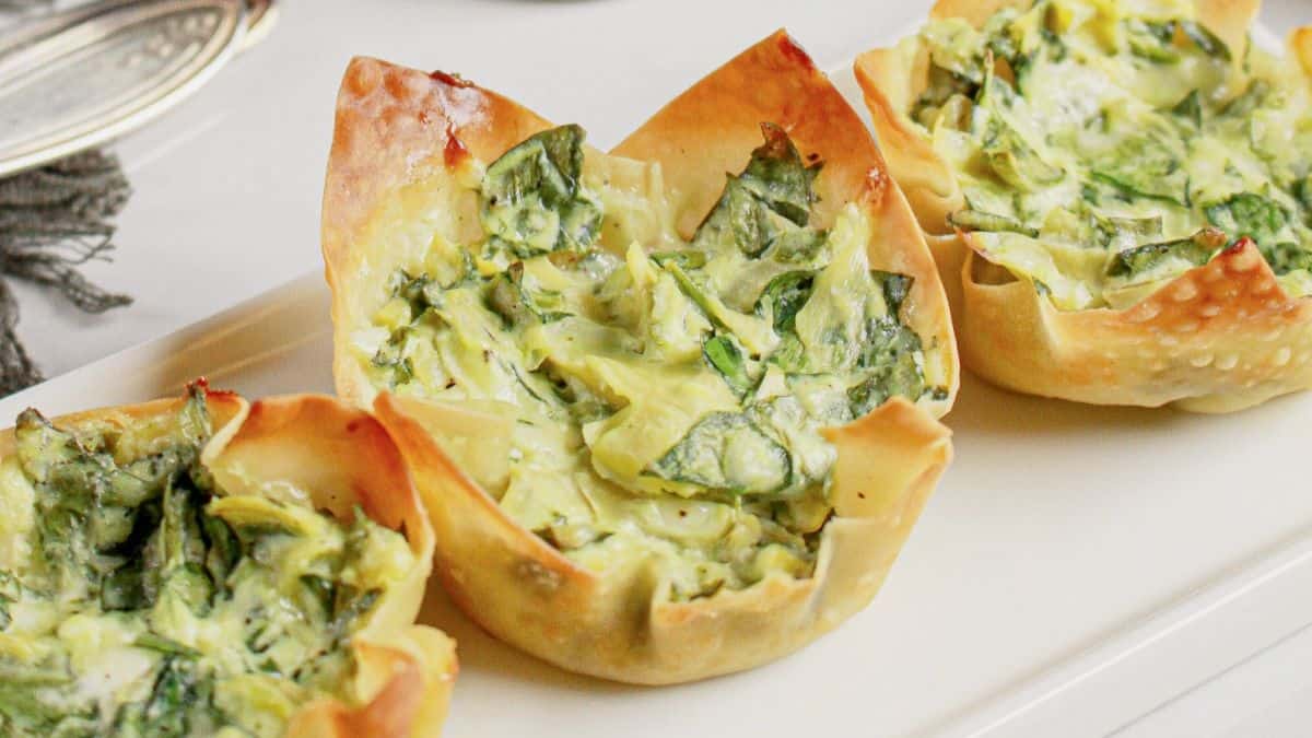 Close-up shot of three pieces of Spinach and Artichoke Wonton Cups.