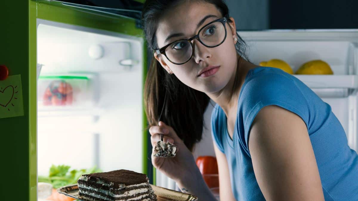 woman eating cake in fridge