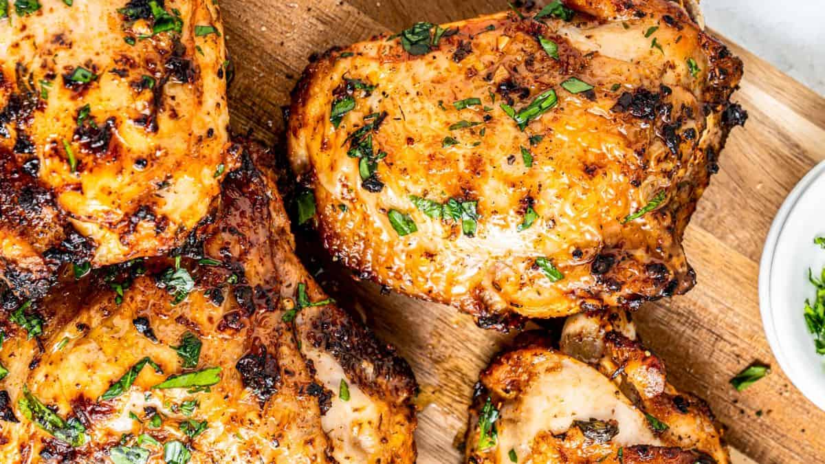 Close-up shot of cooked chicken thighs with some charred parts on it. 