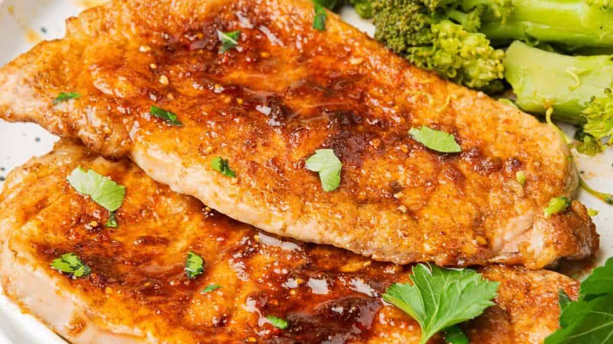 Two thin slices of porkchop cuts  set on a plate. 