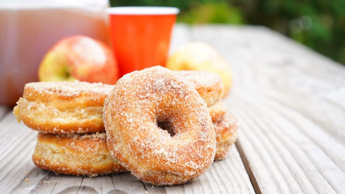 A close-up shot of couple of sugar donuts piled together.
