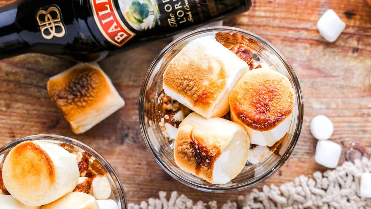 Top shot of two visible glasses of Smores Dessert, and a bottle of Bailey's on the side. 
