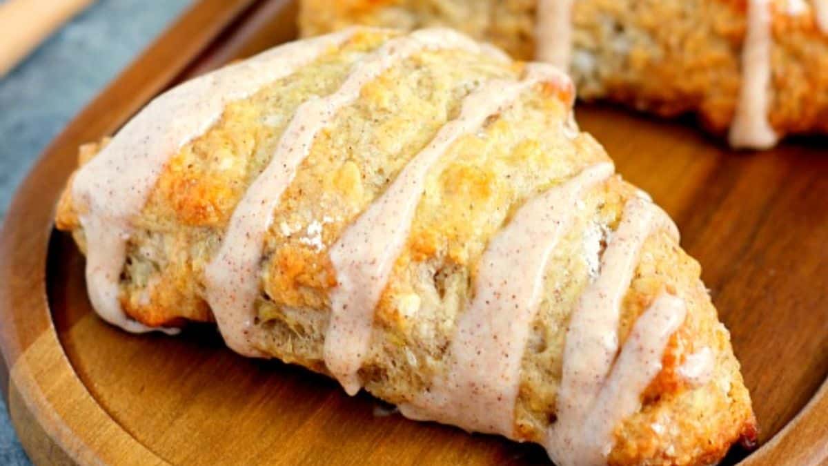 Banana bread scones with cinnamon cream cheese glaze on a plate.