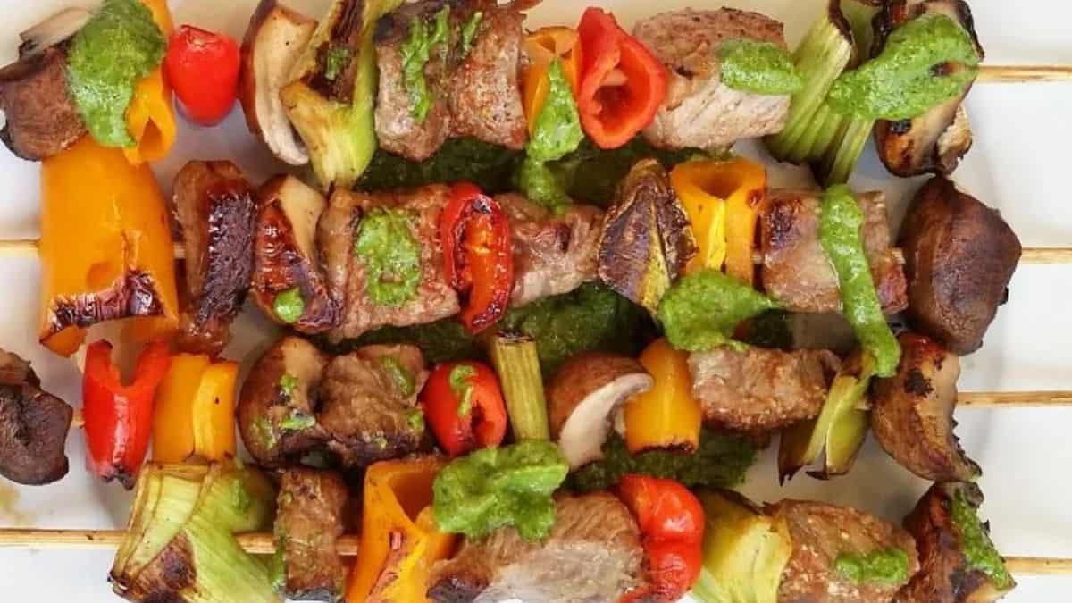Beef shish kabobs served with vibrant cilantro pesto sauce.