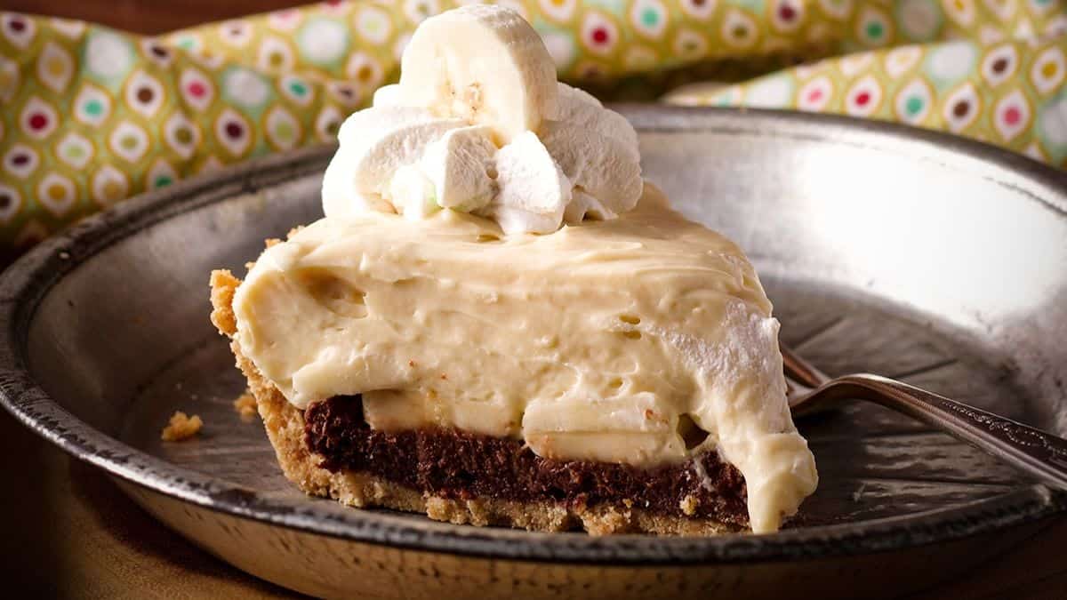 Black bottom banana cream pie slice on a plate.