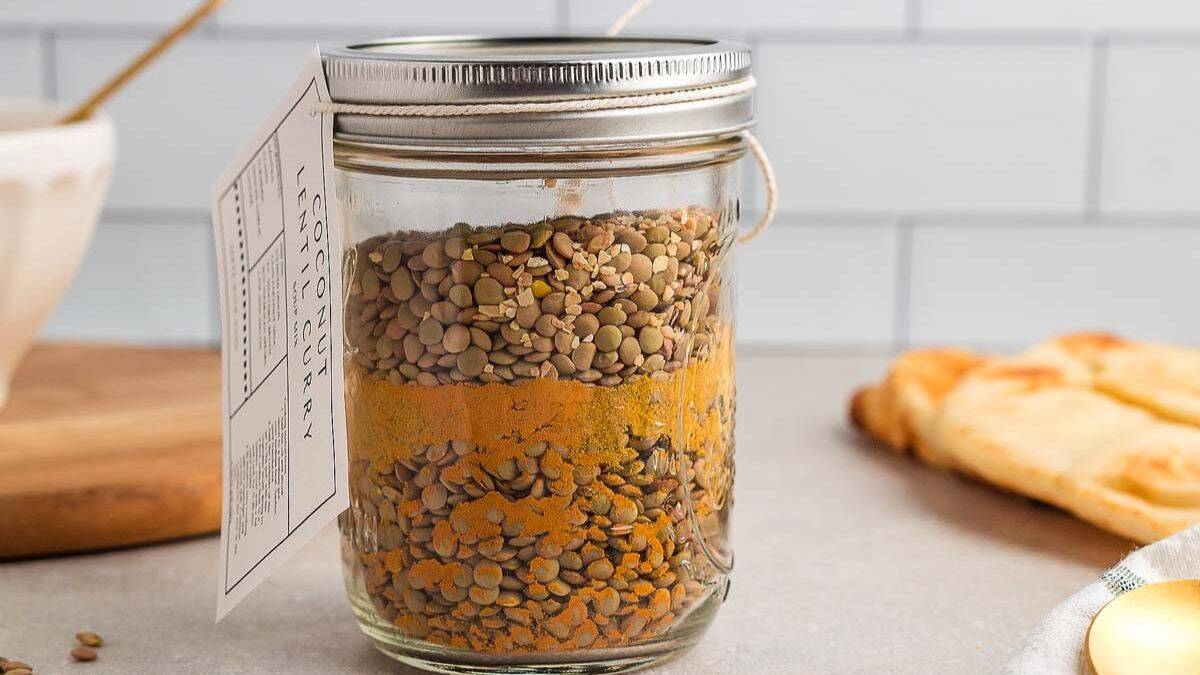 Jar packed with dried lentils, spices, and coconut bits for coconut lentil curry soup mix.