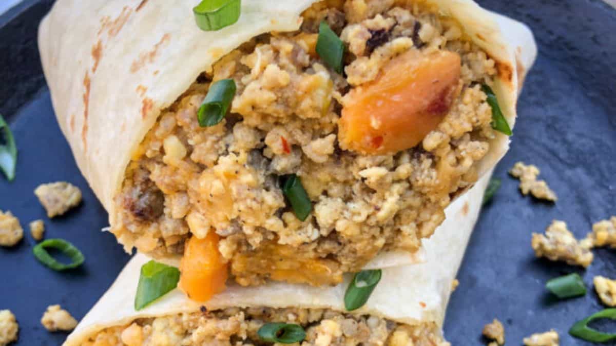 Close up shot of a halved breakfast burrito.