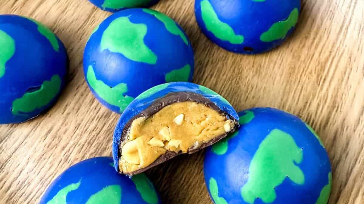 Close-up shot of a couple of pieces of chocolate and peanut butter truffles designed as earth.