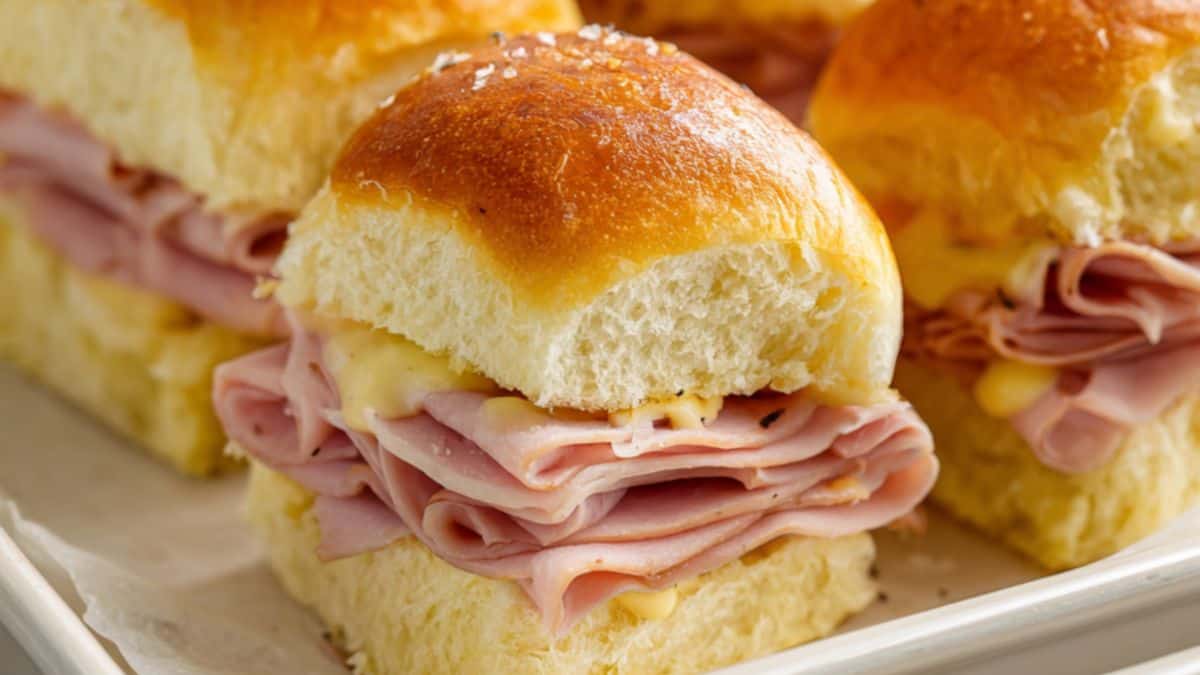 Ham and cheese sliders layered with sliced ham and melted cheese on slider rolls.