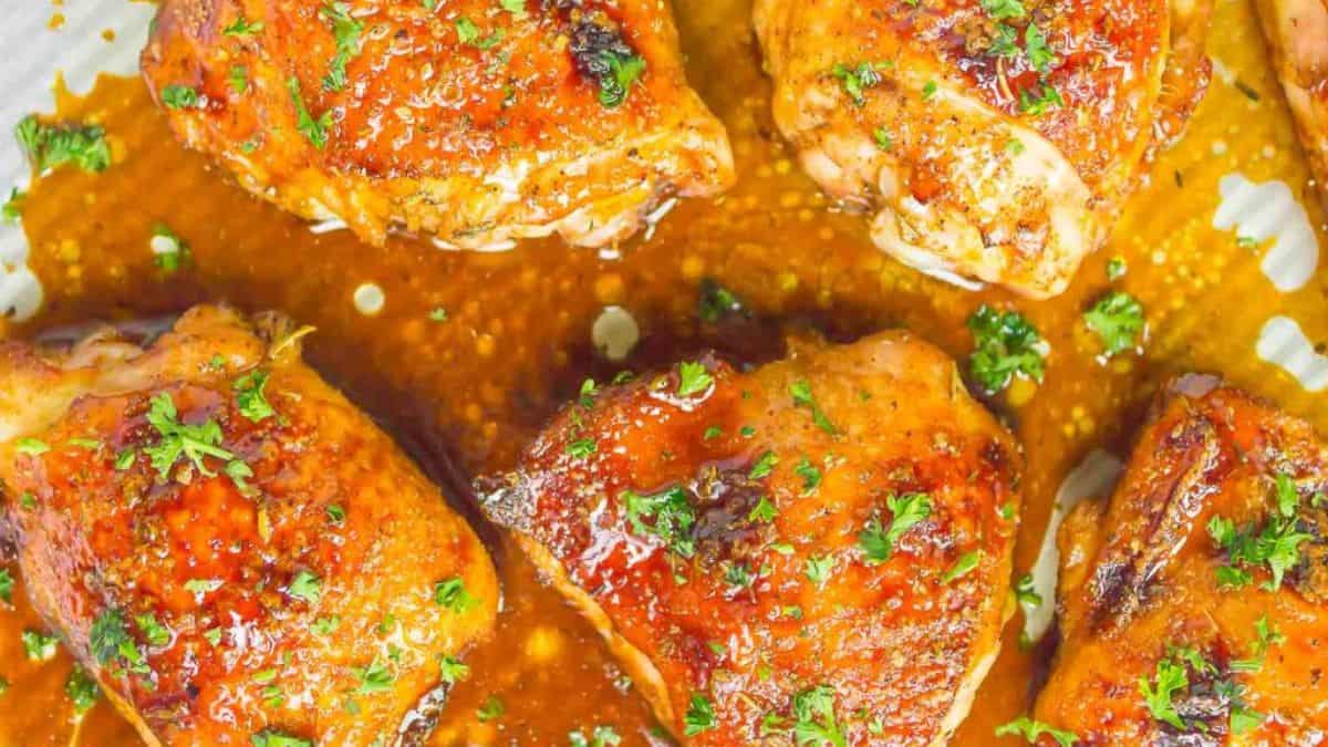 top shot of a couple of pieces of honey balsamic chicken set in a baking pan. 