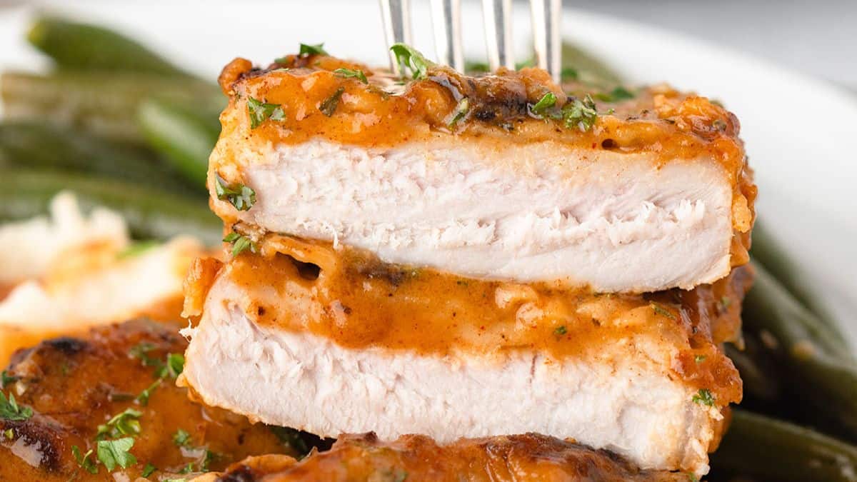 Honey mustard pork chops with sauce and fresh herbs.