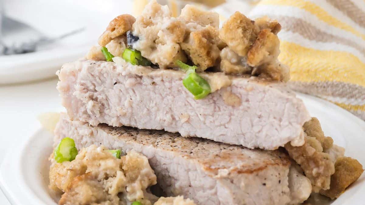 Two cuts of porkchop and stuffing bake set on a plate. 