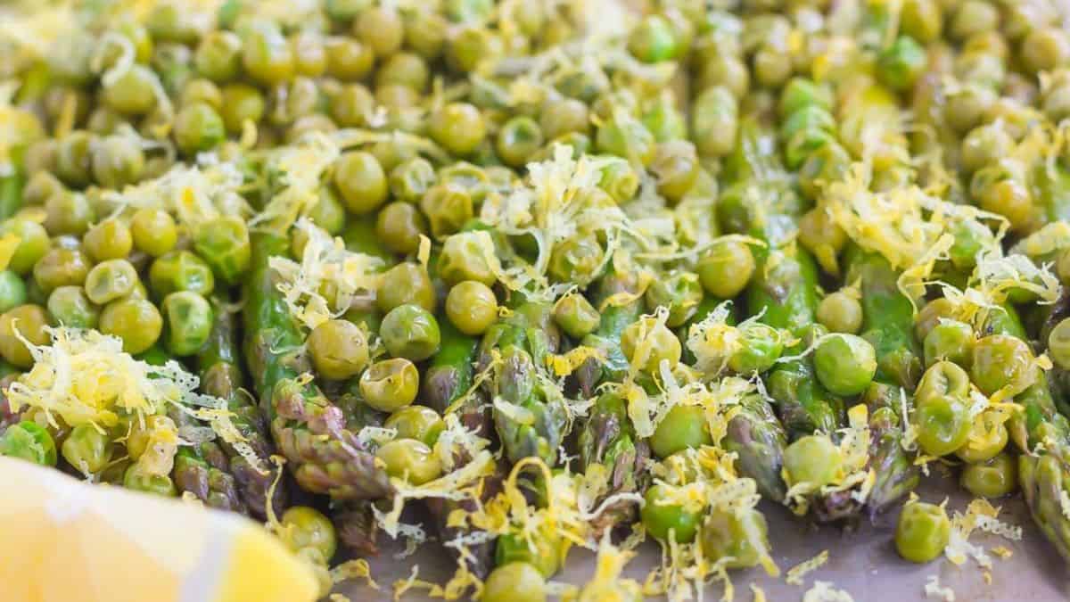 A close-up shot of asparagus and  peas. 