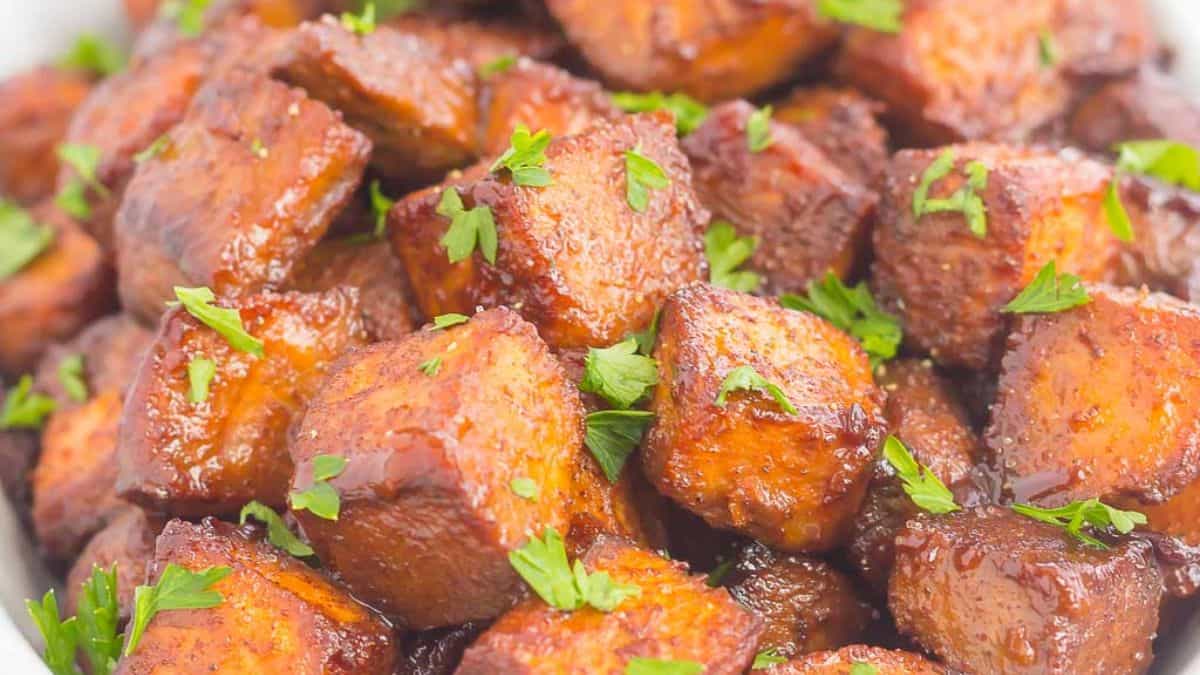 A close-up shot of roasted cinnamon brown sugar sweet potato that are all cut into cubes. 