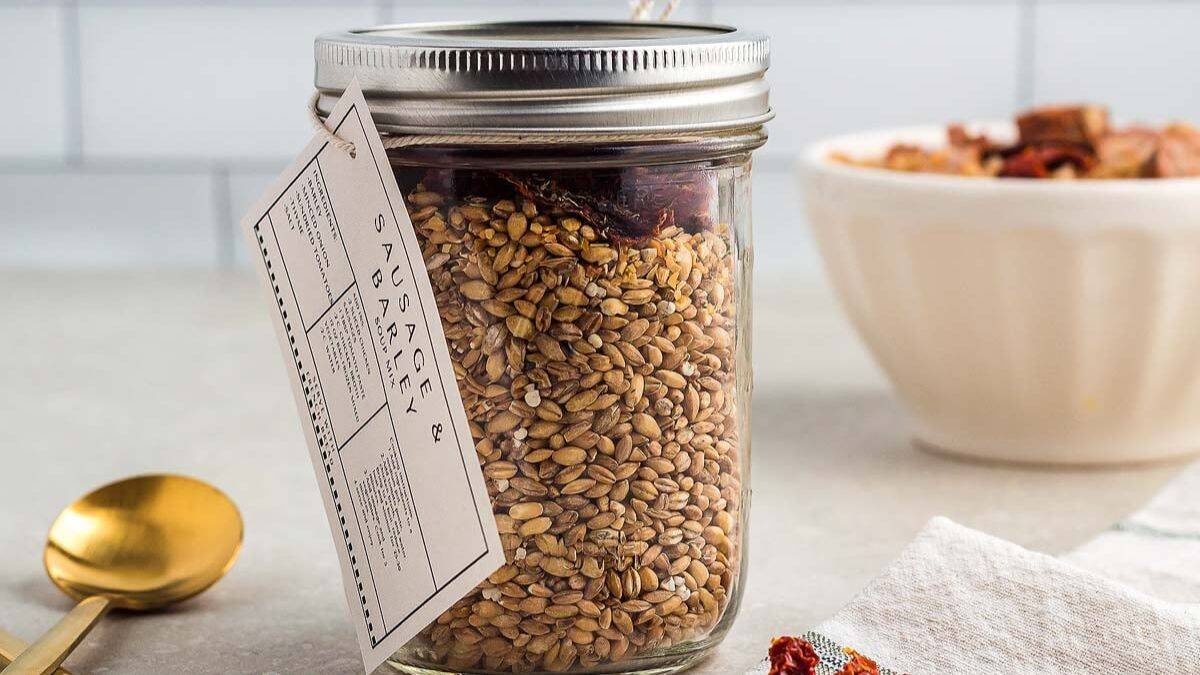 Mason jar of dry ingredients for sausage and barley soup mix.