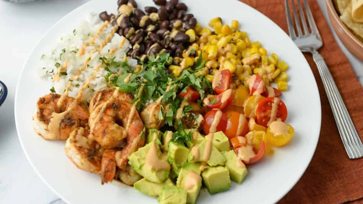 Shrimp burrito bowls with rice, veggies, avocado and seasoned shrimp.