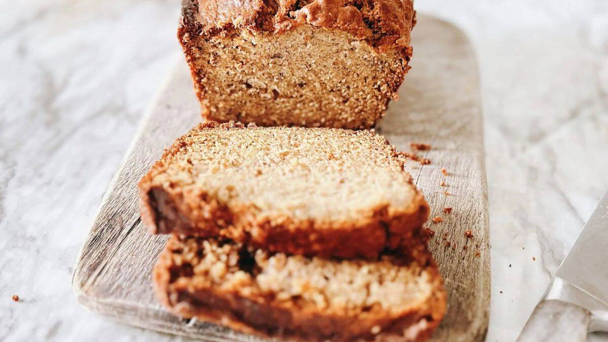 Sourdough banana bread loaf sliced on a cutting board.