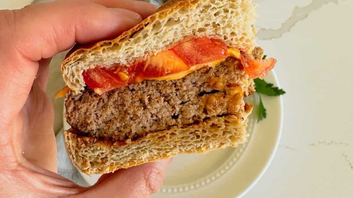 A half of burger held by a hand. 