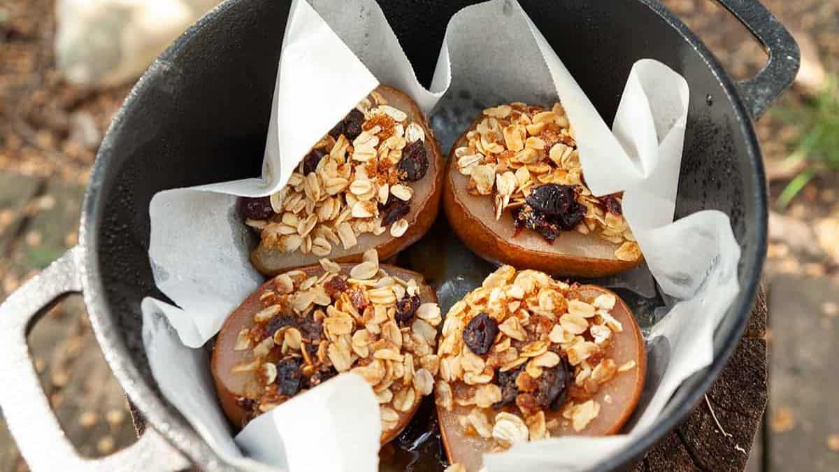 Dutch Oven lined with parchment paper, and 4 pieces of stuffed pears on top of it.