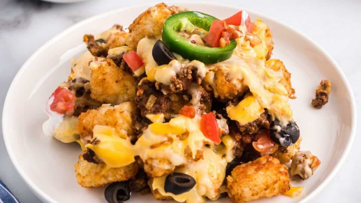 Loaded tater tots served on a plate.
