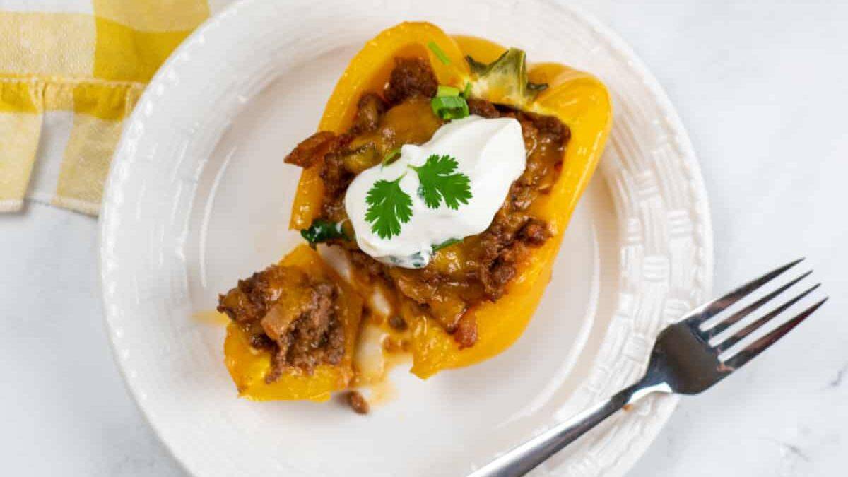 Taco stuffed bell peppers filled with seasoned beef, cheese and toppings.