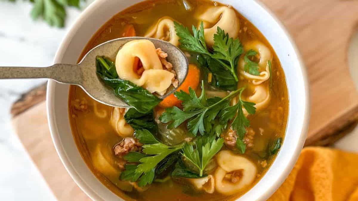 Hearty Instant Pot tortellini soup with spinach, carrots, and cheese-filled tortellini in a bowl.
