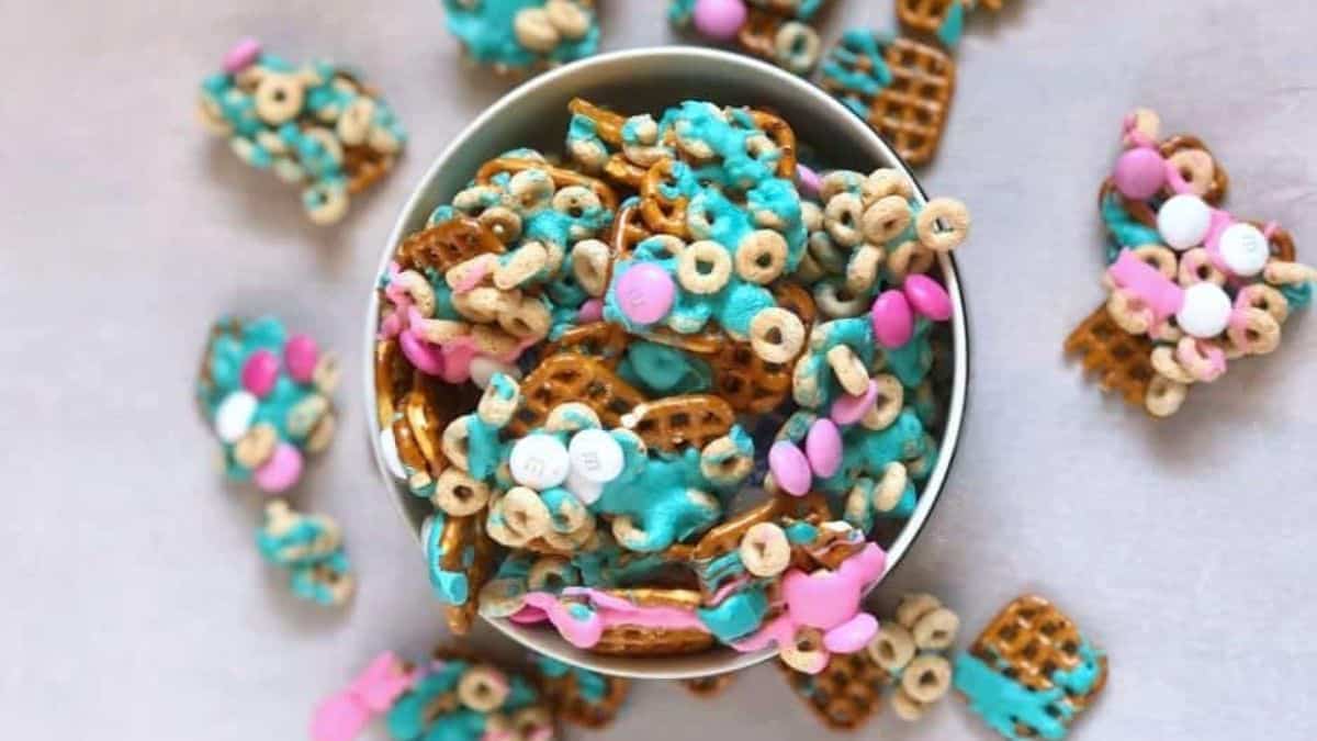 Top shot of a small bucket filled with Chex mixed with melted chocolate, and some loops cereal.