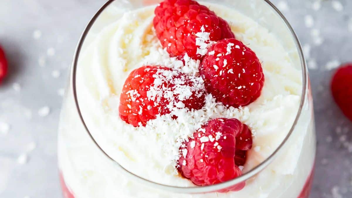 Top shot of a glass with White chocolate mousse then topped with raspberries. 