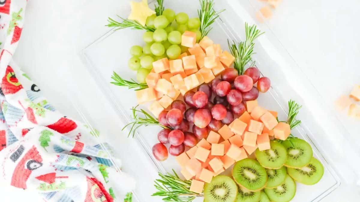 Fruit and cheese platter designed as a Christmas tree. Grapes, cheese cubes, grapes, kiwis. 