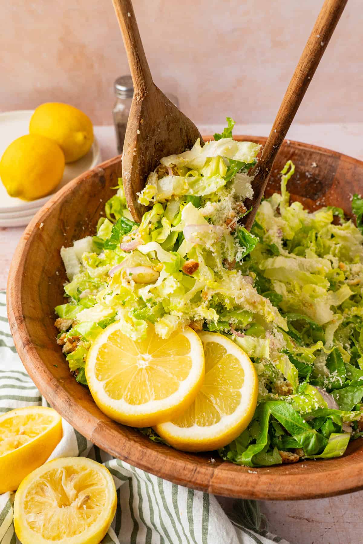 Using wooden spoons to toss the salad. 