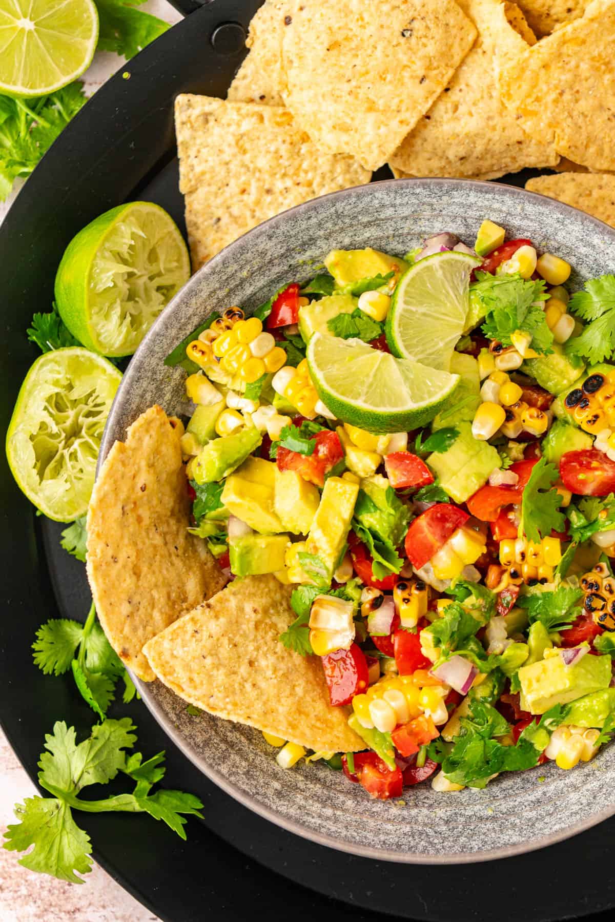 A bowl with avocado salsa and chips for serving. 