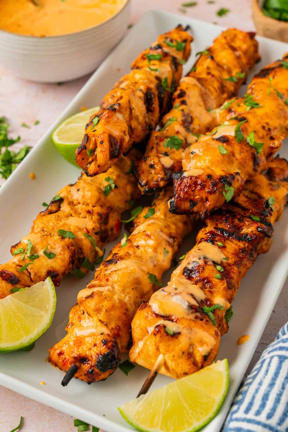 Bang bang chicken skewers drizzled with extra sauce. 