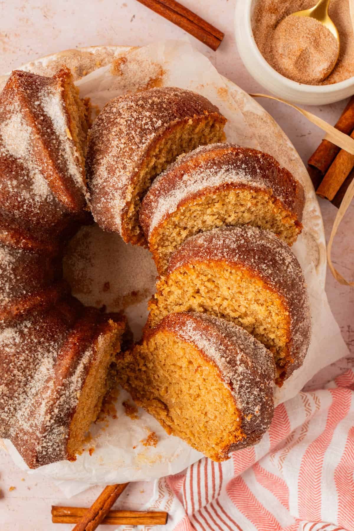 Sliced apple cider donut cake showing the soft, moist crumb and cinnamon sugar crust