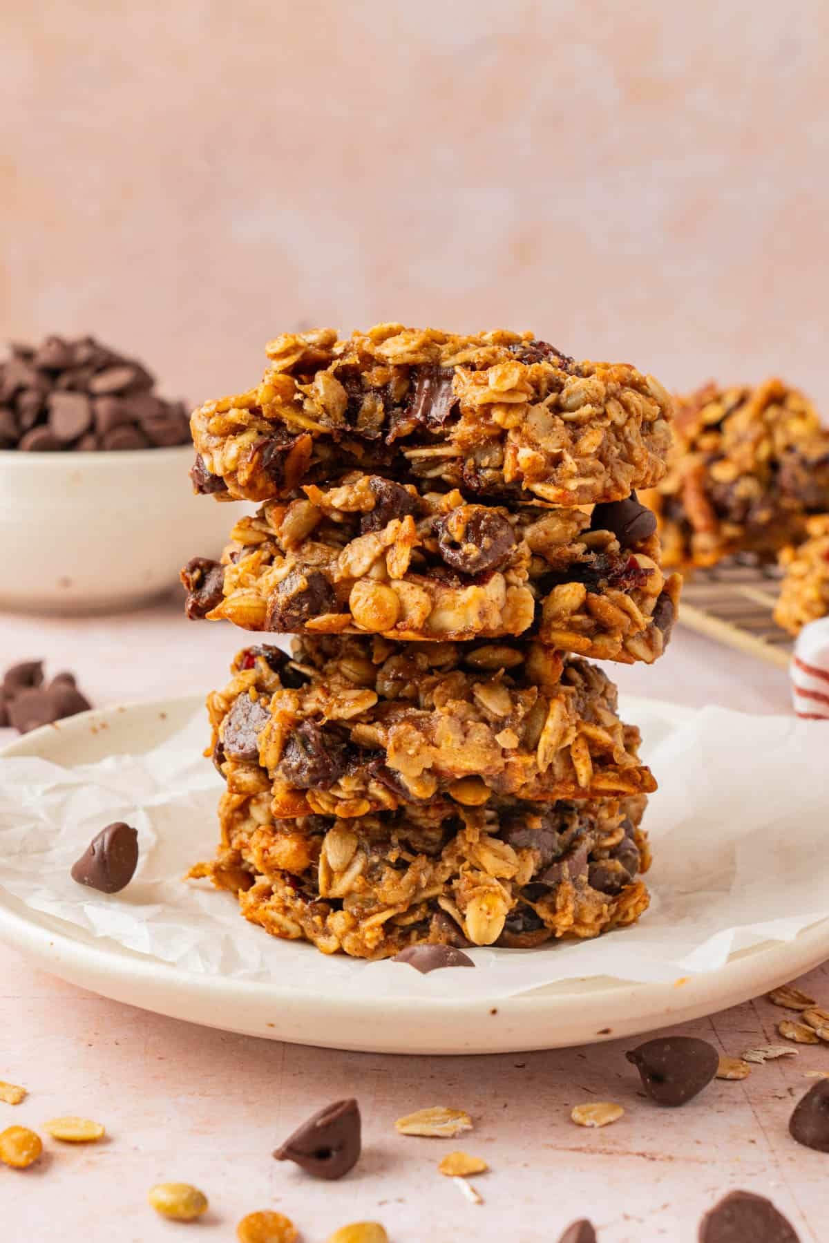 Stack of oatmeal breakfast cookies on a white plate with the top cookie split open to show the chewy, high protein breakfast cookie texture