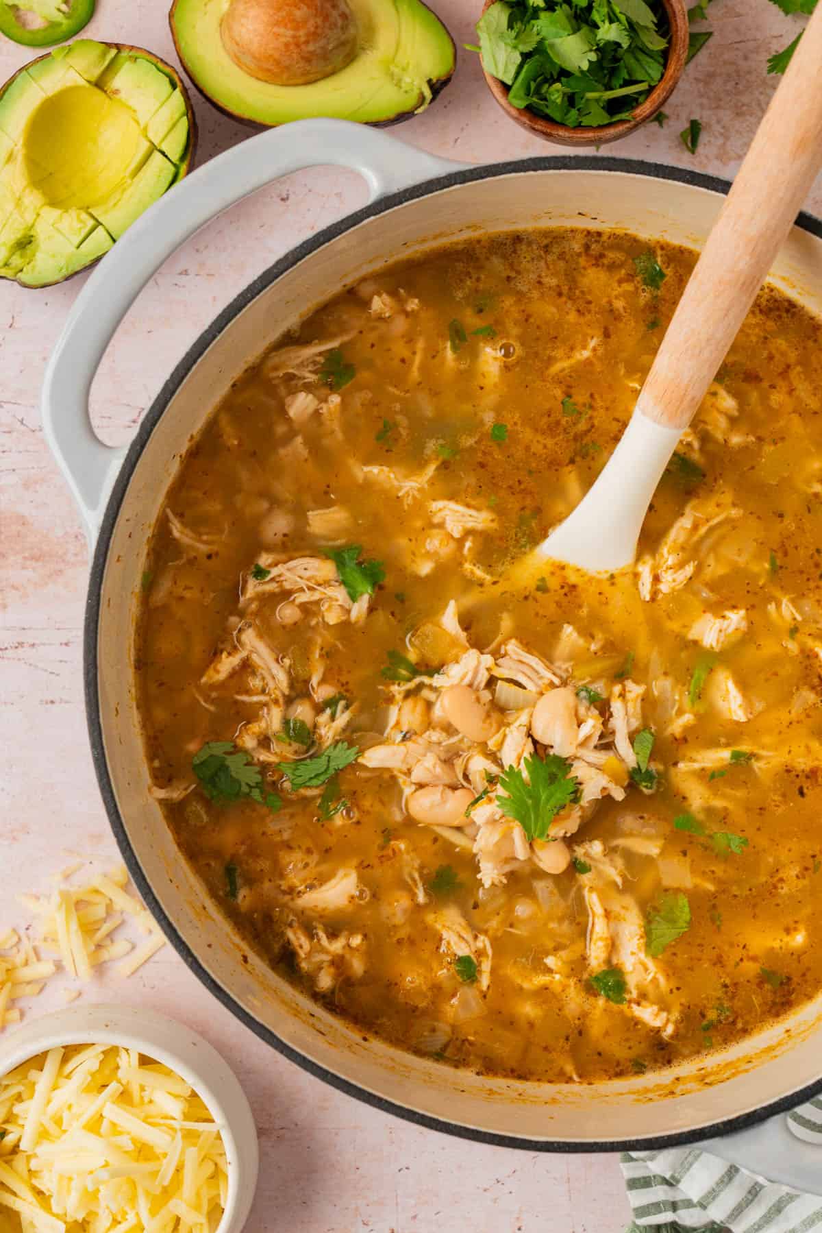 Pot of white bean chicken chili with garnishes on the side